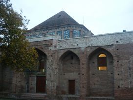 نمایی از مقبره مشهد میربزرگ با گنبدی مثلثی شکل و بنایی آجری